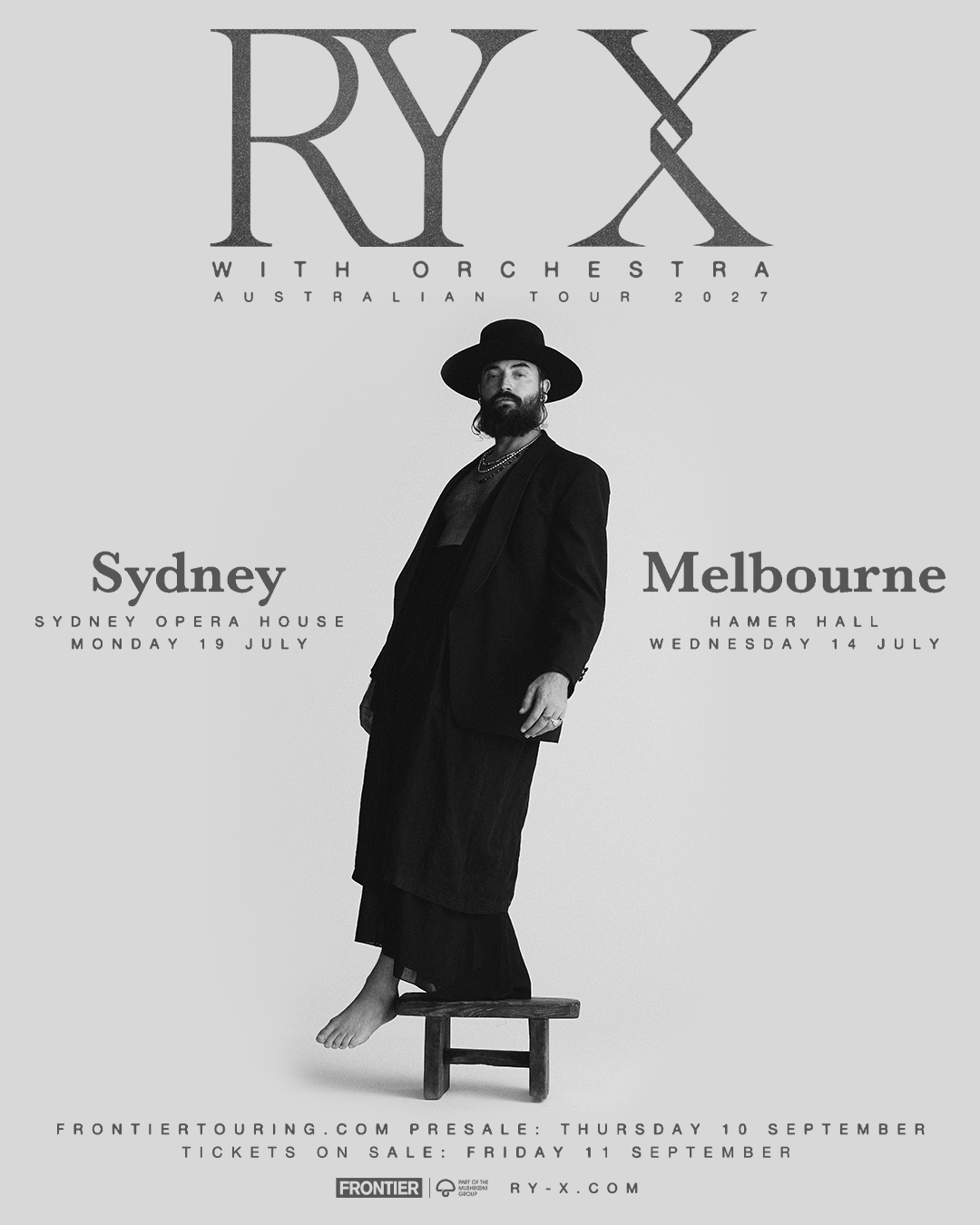 Tour poster for RY X With Orchestra Australian Tour 2027 featuring RY X standing on a wooden stool in black attire on a grey backdrop.